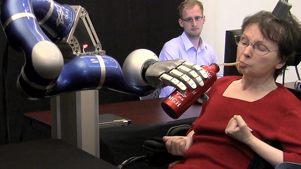Mulher paralisada usa braço mecânico controlado pela mente para levar líquido à boca