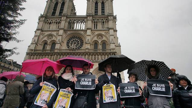 Pessoas prestam um minuto de silêncio em frente à catedral de Notre Dame, em Paris, em memória das vítimas do ataque à redação da revista Charlie Hebdo - 08/01/2015