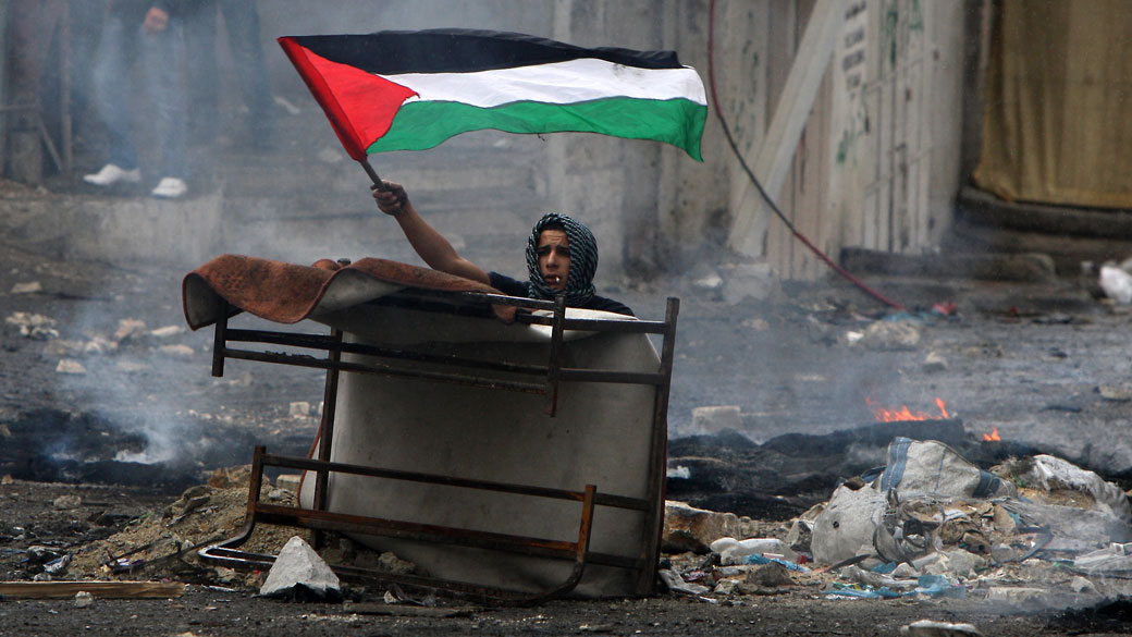 Jovem balança bandeira palestina