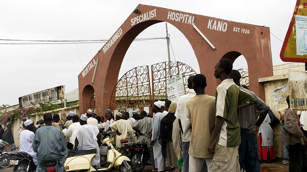 Pessoas buscam seus parentes desaparecidos em frente do portão do Hospital Especialista Murtala Mohammed em Kano, Nigéria