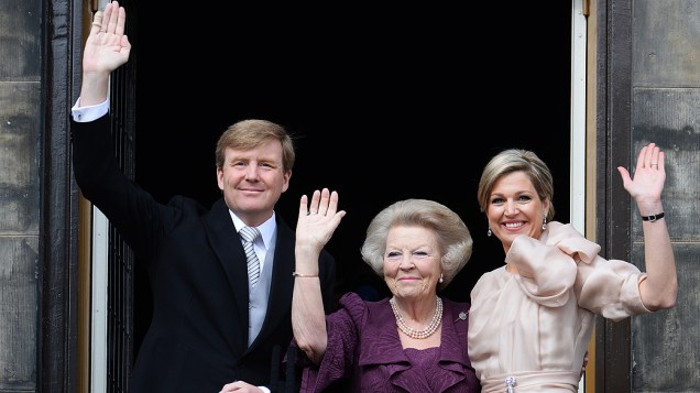 Os novos monarcas da Holanda, o rei Willem-Alexander e a rainha Máxima, acenam ao público do Palácio Real, ao centro a agora princesa Beatrix