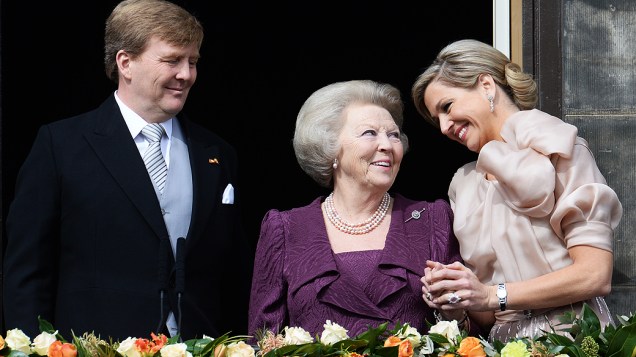 Os novos monarcas da Holanda, o rei Willem-Alexander e a rainha Máxima, acenam ao público do Palácio Real, ao centro a agora princesa Beatrix
