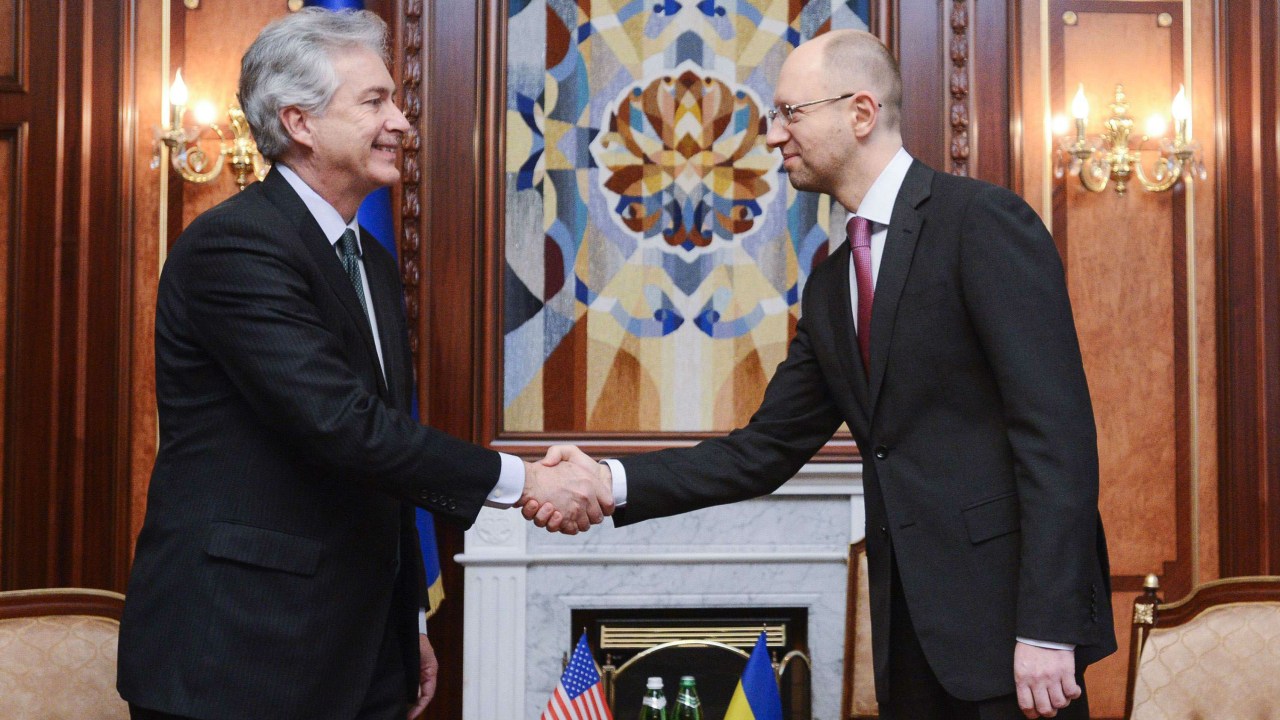 O novo primeiro-ministro interino da Ucrânia, Arseny Yatsenyuk (à dir.), cumprimenta o vice-secretário de estado americano, William Joseph Burns