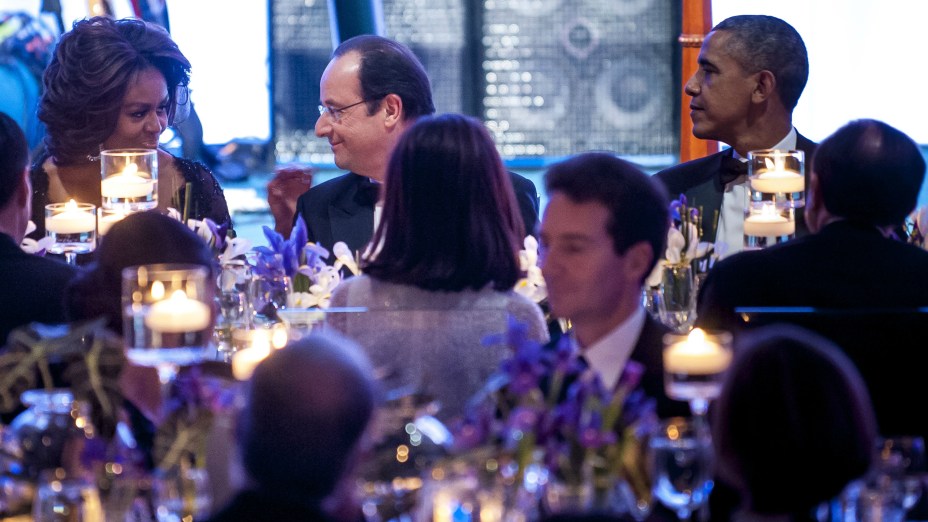 O presidente francês François Hollande senta entre os anfitriões americanos Michelle e Barack Obama durante o jantar de estado servido na Casa Branca