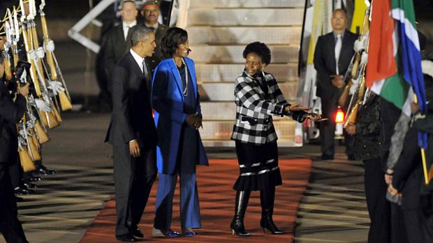 O presidente Barack Obama e a primeira-dama Michelle são recebidos pela ministra de Relações Internacionais e Cooperação Maite Knoana-Mashabane em base aérea em Pretória, na África do Sul