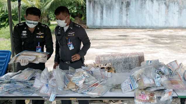 Policiais separam malas cheias de objetos de vítimas do tsunami de 2004 em uma delegacia em Takua Pa, na província de Phang Nga, na Tailândia