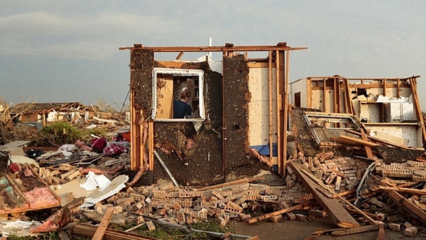 Mulher faz busca em casa que foi quase totalmente destruída pelos tornados