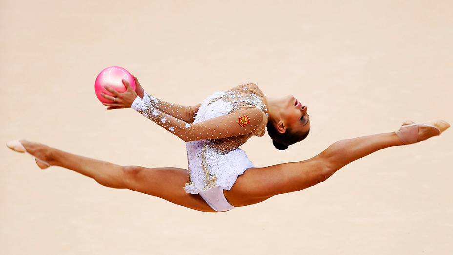 A russa Evgeniya Kanaeva se apresenta com a bola durante as classificatórias individuais da ginástica rítmica