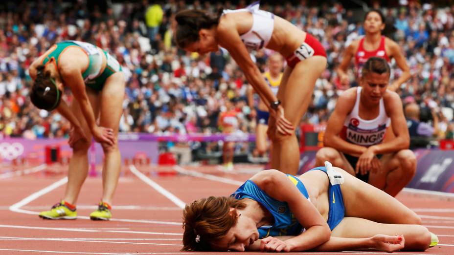 Valentyna Horpynych Zhudina da Ucrânia desaba de cansaço na pista após a prova dos 3000m com obstáculos durante os Jogos Olímpicos de Londres 2012