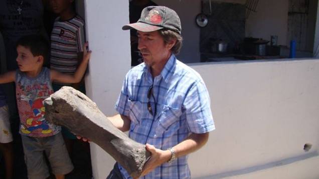 <p>Coordenador de Geologia da UFPE, Edison Vicente, segura osso de mamífero não identificado</p>