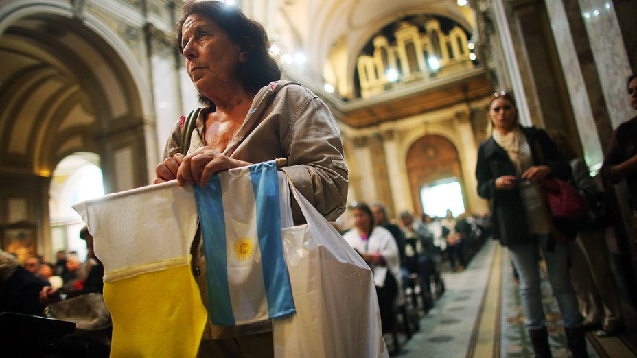 Fiel assiste à missa segurando a bandeira da Argentina na Catedral Metropolitana, em Buenos Aires