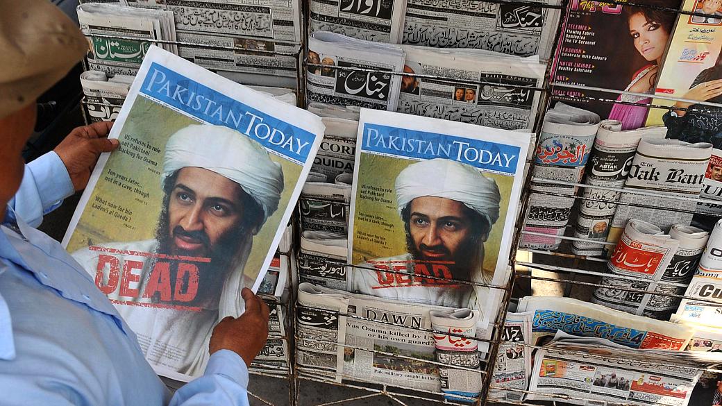 Paquistanês lê jornal com informações sobre a morte de Osama bin Laden, em Lahore, na terça-feira