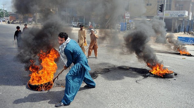 Paquistanês protestas queimando pneus em Rawalpindi, nesta sexta-feira. Cinemas no país foram queimados
