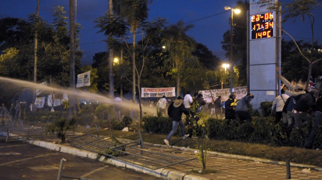Policiais dispersam com jato dàgua partidários do presidente deposto Fernando Lugo, no Paraguai Policiais dispersam com jato dàgua partidários do presidente deposto Fernando Lugo, no Paraguai