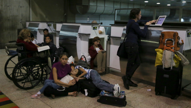 Passageiros aguardam no chão após serem retirados ao avião da Air France em Caracas, na Venezuela, que iria decolar com destino a Paris