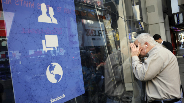Pedrestre observa janela do prédio da Nasdaq, em Nova York, onde acontece a estreia do Facebook no mercado financeiro