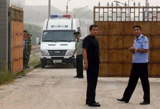 Policiias chineses em frente à prisão após a libertação de Wang Xiaoning em Pequim