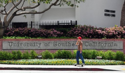 Estudante anda de skate na entrada da Universidade de Southern California