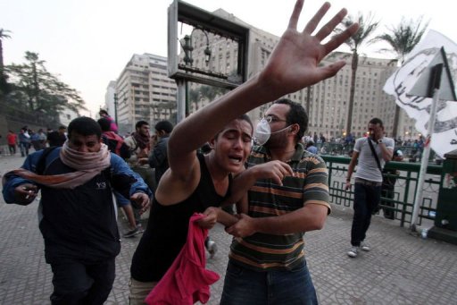 Manifestantes correm para se proteger das bombas de gás lacrimogêneo da polícia no Cairo