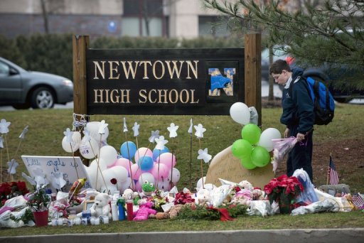 Estudante observa as homenagens às vítimas do tiroteio na escola primária Sandy Hook em Newtown, Connecticut
