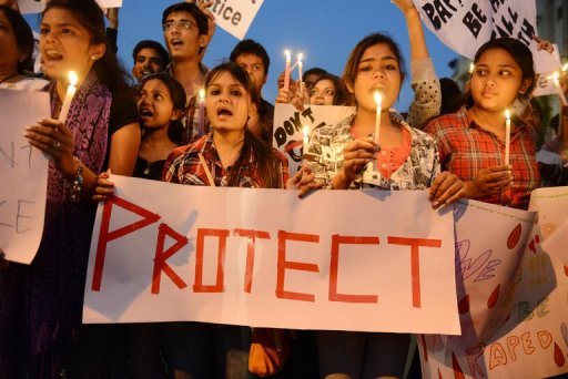 Jovens indianos seguram velas e cartazes em uma vigília após o estupro coletivo de uma estudante em Ahmedabad
