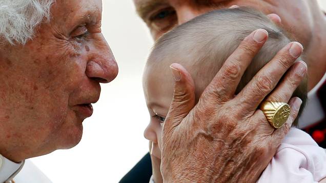 O Papa Bento XVI beija criança durante audiência no Vaticano