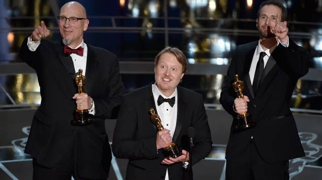 O diretor Don Hall (centro) recebe o Oscar de melhor animação por Operação Big Hero