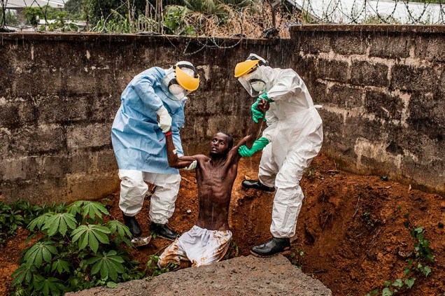 Pete Muller, dos EUA, venceu na categoria "Histórias Gerais" com a foto de agentes de saúde tratando de um homem com ebola em Serra Leoa