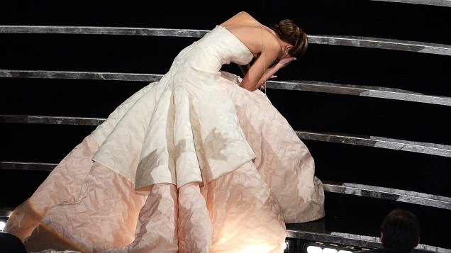 Jennifer Lawrence cai no caminho para receber a estatueta de melhor atriz