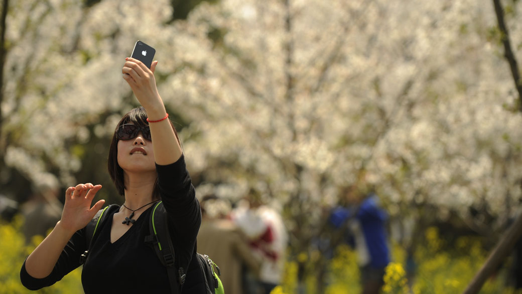 Turista tira fotos de paisagem no início da primavera em Xangai, na China