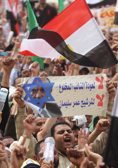 Manifestante segura cartaz com foto de Omar Suleiman, ex-vice-presidente e chefe da inteligência no mandato de Mubarak, durante protesto na praça Tahir no Cairo, Egito