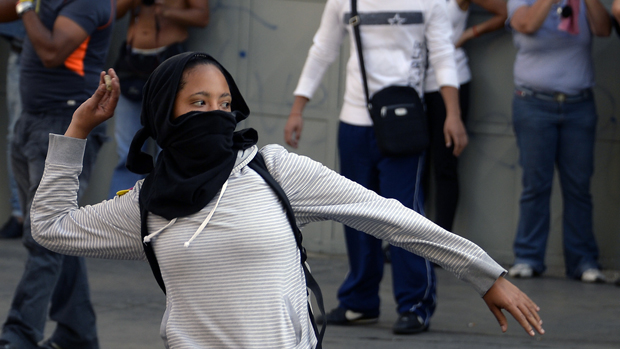 Manifestante joga pedra durante protesto contra o governo da Venezuela