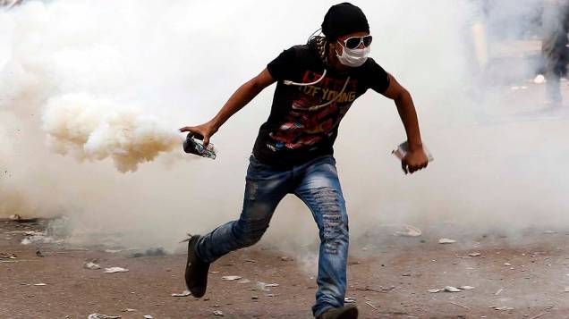 Manifestante contrário ao presidente Mohamed Mursi segura lata de gás lacrimogênio durante confronto com a polícia perto da Praça Tahrir, no Cairo