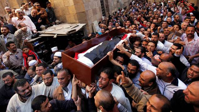 Partidários do presidente Mohamed Mursi carregam caixão de Mohamed Mamdouh al-Husseini, morto em confronto em frente ao Palácio Presidencial, em 07/12