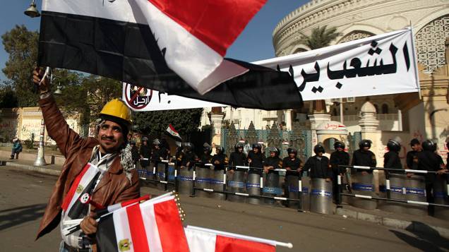 Vendedor de bandeiras e policiais em frente ao Palácio Presidencial, no Cairo