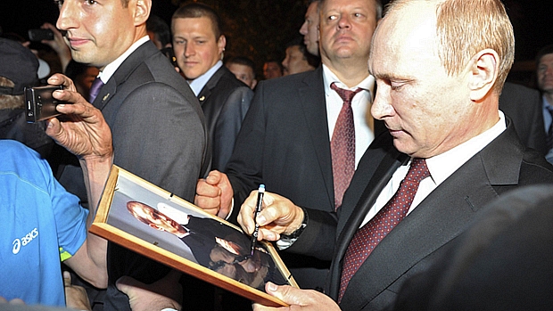 Putin assina quadro com sua fotografia na cidade de Chita, onde falou sobre o caso Snowden