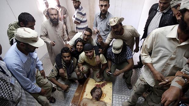Rebeldes se aglomeram para tirar foto ao lado do corpo de Kadafi em Misrata, nesta sexta-feira, 21/10/2011