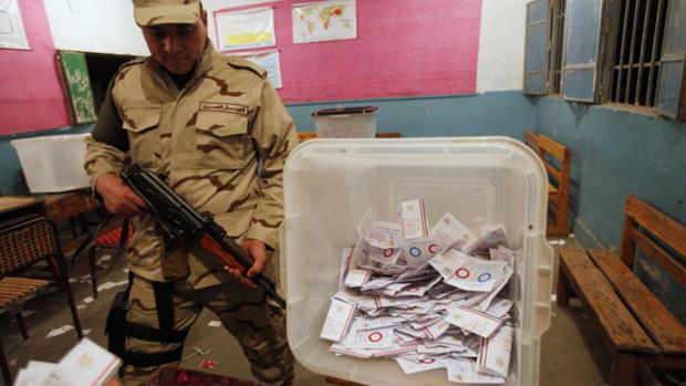 Soldado é fotografado ao lado de cédulas depois do encerramento da votação do referendo sobre a Constituição do Egito