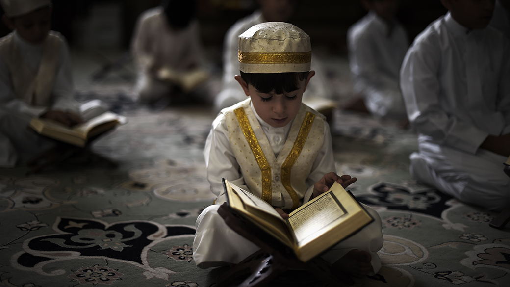 Um menino muçulmano xiita do Bahrein lê o Corão, o livro sagrado do Islã, durante o mês do Ramadã, em uma mesquita na aldeia de Sanabis, oeste do país