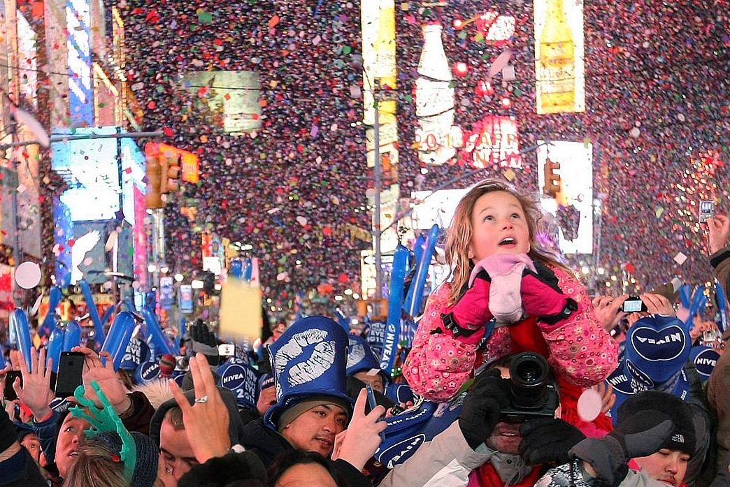 Garota observa bola luminosa descer por poste a anunicar a chegada de 2013 em Nova York