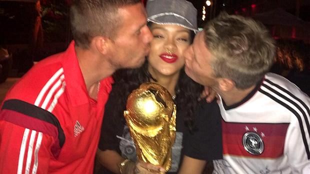 Rihanna segura a taça com os jogadores alemães Podolski e Schweinsteiger