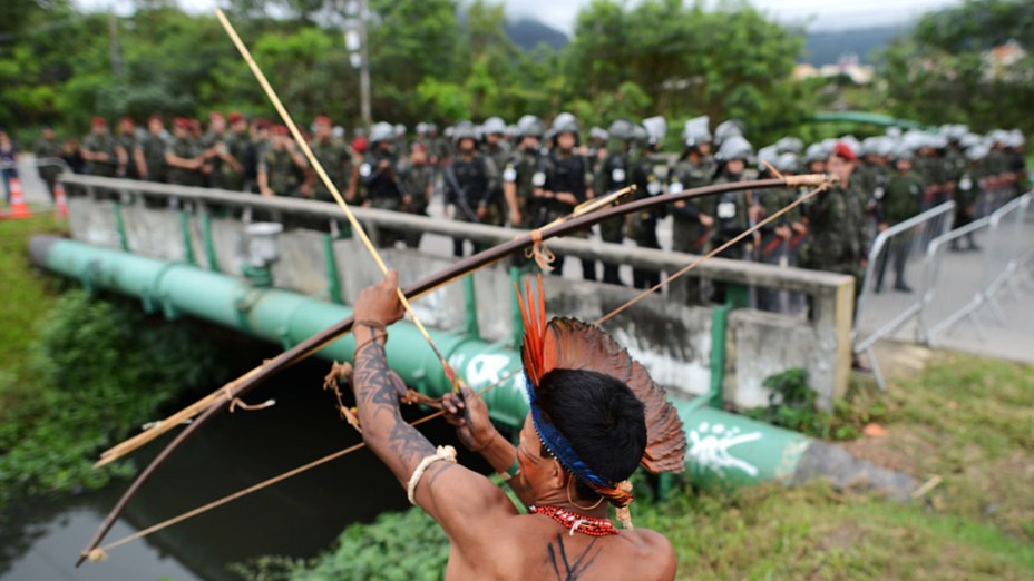 Indígenas brasileiros realizam protestos diante de militares durante a Rio+20