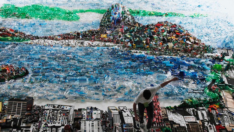 Homem dá retoques finais na imagem da Baía de Guanabara feitas de lixo reciclado, parte de uma instalação do artista brasileiro Vik Muniz, durante a Rio +20