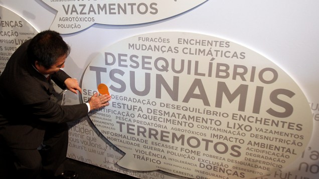 O cônsul japonês Masaru Watanabe coloca adesivo sobre a palavra tsunami durante a Rio+20