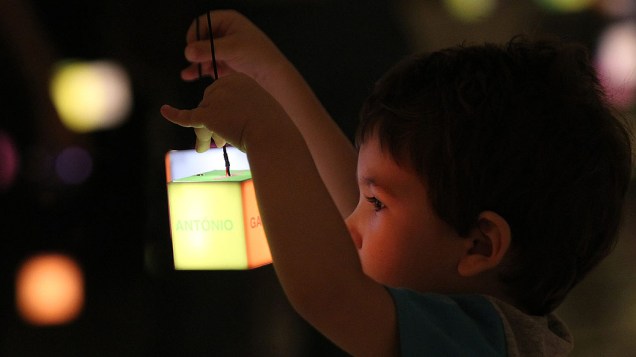 Criança brinca com as luzes durante exposições de "Future Project", no Forte de Copacabana
