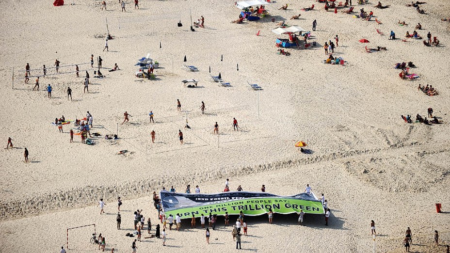 Ambientalistas exibem faixa em que pedem o fim de subsídios para a produção de combustíveis fósseis, na praia de Copacabana