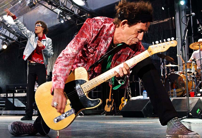 O guitarrista Keith Richards e o vocalista Mick Jagger ao fundo durante show de 2003 em Munique, Alemanha