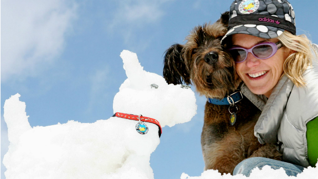 Oscar e sua dona, Joanne Lefson, ao lado de cachorro de neve