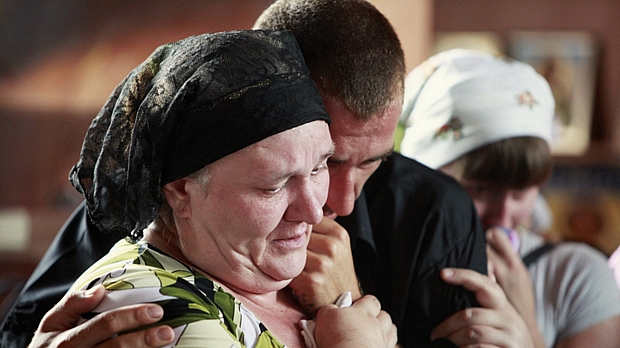 Familiares de vítima das enchentes na Rússia