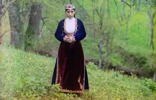 Uma mulher armênia com trajes tradicionais do país posa para o fotógrafo Prokudin-Gorskii em uma colina perto de Artvin (atual Turquia), por volta de 1910